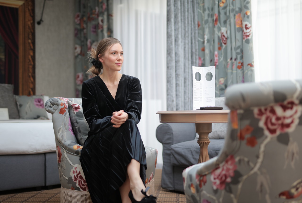 woman-in-black-long-sleeve-dress-sitting-on-a-chair-3923539